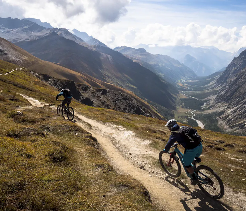 Nate Hills and Francesco Gozio riding singletrack above the valley