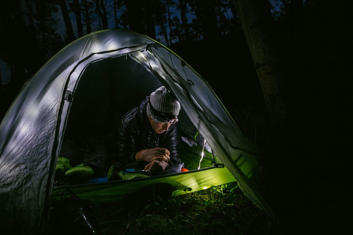 Justin Reiter settling into a illuminated tent off the Colorado Trail for the night 